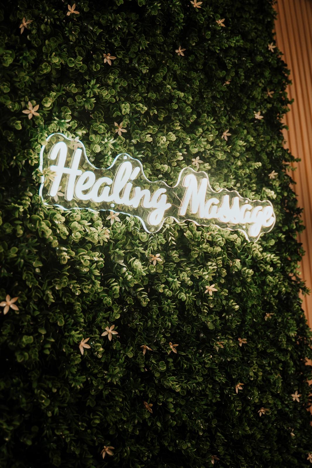 Parede verde com letreiro luminoso Healing Massage